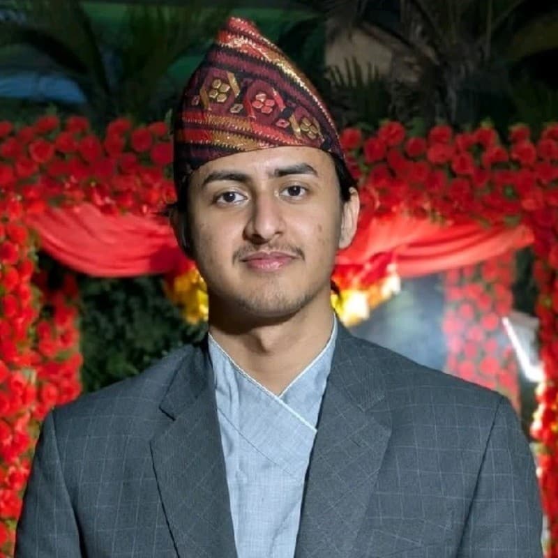Diwash Lamichhane wearing a Nepali topi and suit